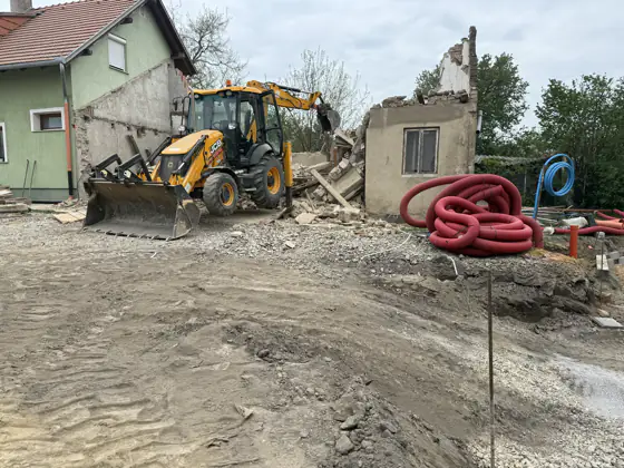 Bontási törmelék a géppel a háttérben