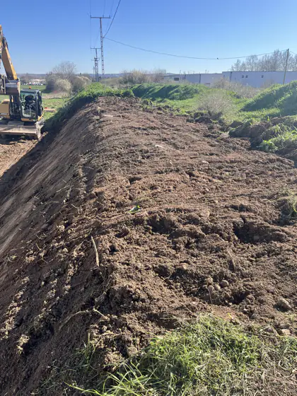 Depónia és kotrógép a munkaterület szélén