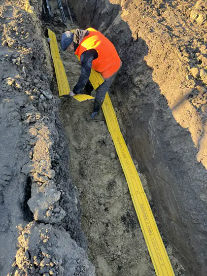 Munkatárs kábelárokban, napelempark építésén